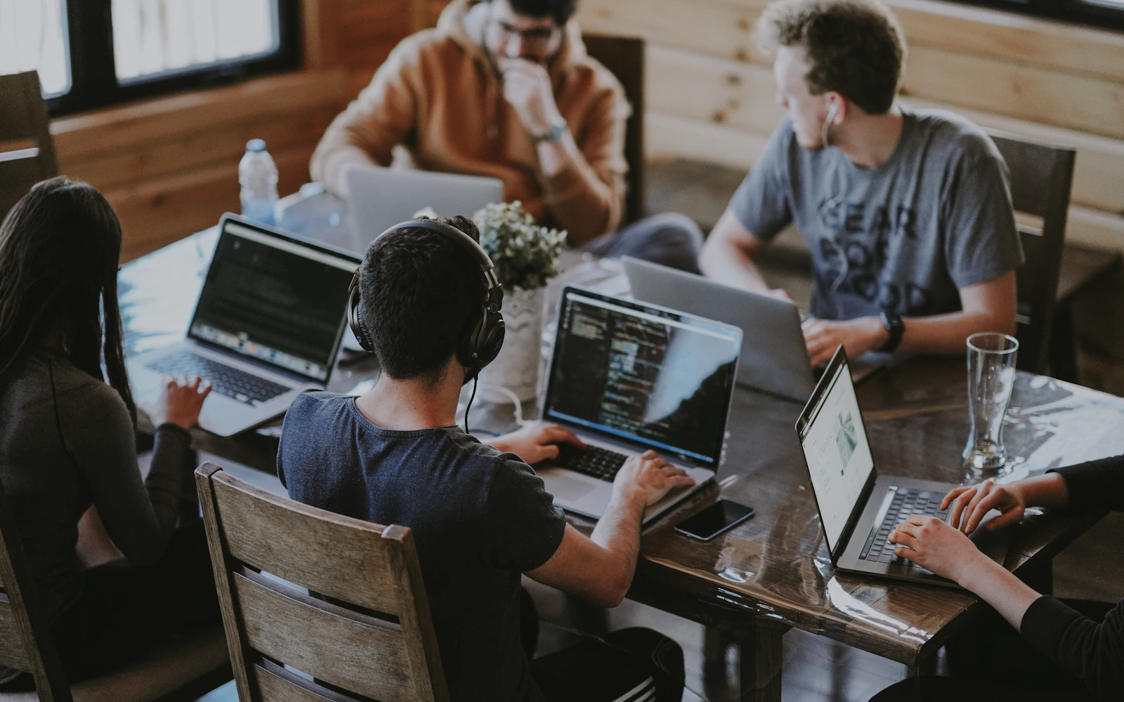 Tim bekerja bersama dengan laptop untuk menyelaraskan pekerjaan